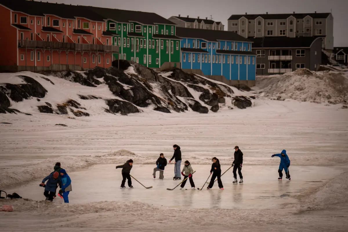 La gente juega sobre una superficie helada en Nuuk, Groenlandia, el 16 de febrero de 2025. (AP Photo/Emilio Morenatti).
