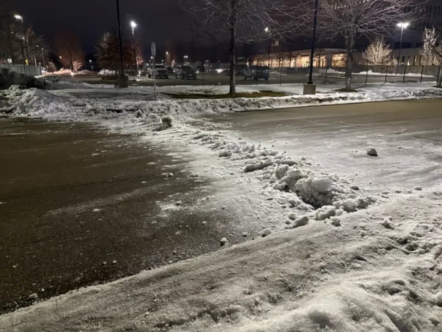 Un manifestante anti-ICE intentó amontonar nieve en la carretera cerca del Edificio Federal Bishop Henry Whipple el 9 de enero de 2026, en un intento por dificultar que las fuerzas del orden salieran del área. (Nathan Worchester/The Epoch Times)