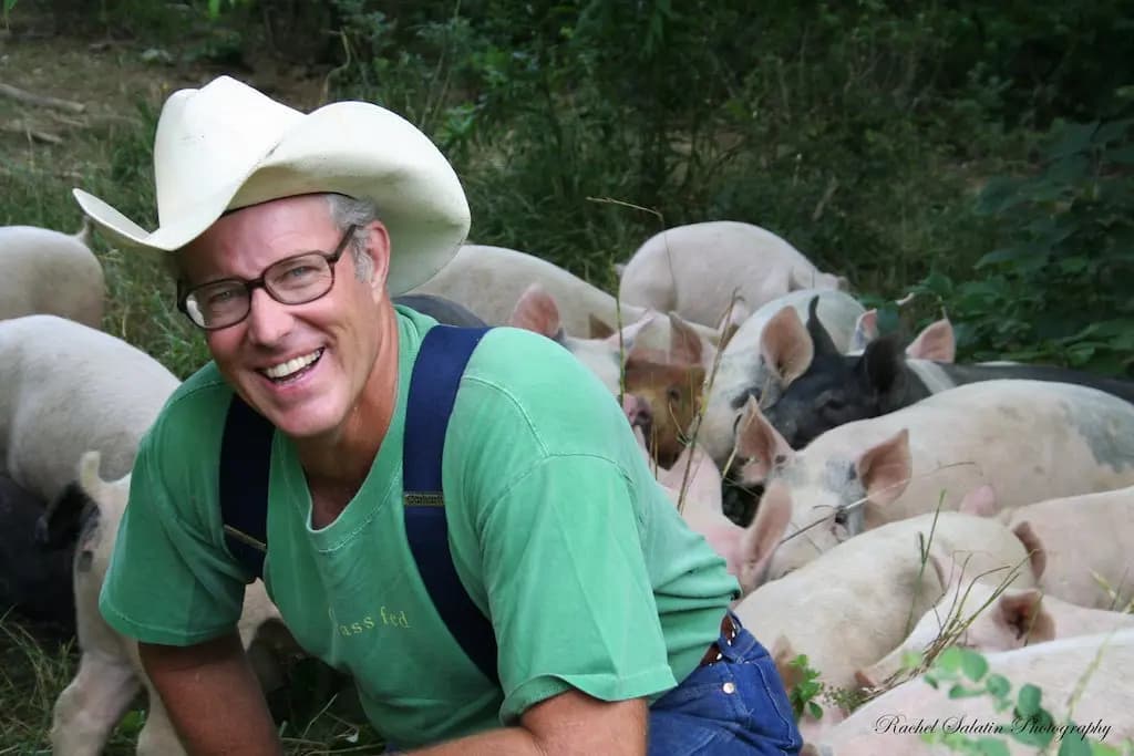 Joel Salatin fotografiado con sus cerdos en Polyface Farm, una granja regenerativa en Virginia. Cortesía de Polyface Farm.