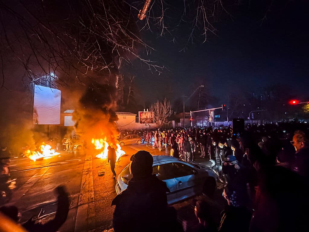 Iraníes se congregan mientras bloquean una calle durante una protesta en Teherán, Irán, el 9 de enero de 2026. Las protestas a nivel nacional comenzaron en el Gran Bazar de Teherán a finales de diciembre contra el fracaso de las políticas económicas, se extendieron a universidades y otras ciudades e incluyeron consignas que abarcaban desde económicas hasta políticas y antigubernamentales. (Foto de MAHSA / Middle East Images / AFP vía Getty Images)