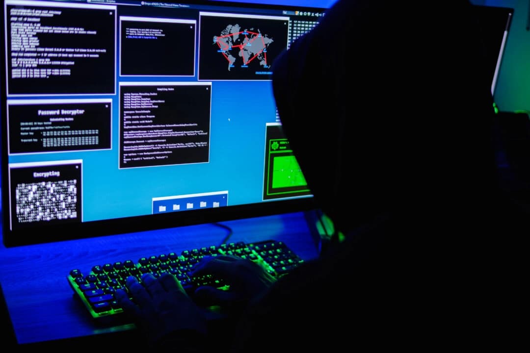 En esta ilustración fotográfica, un hacker teclea en un ordenador el 13 de mayo de 2025. (Oleksii Pydsosonnii/The Epoch Times)