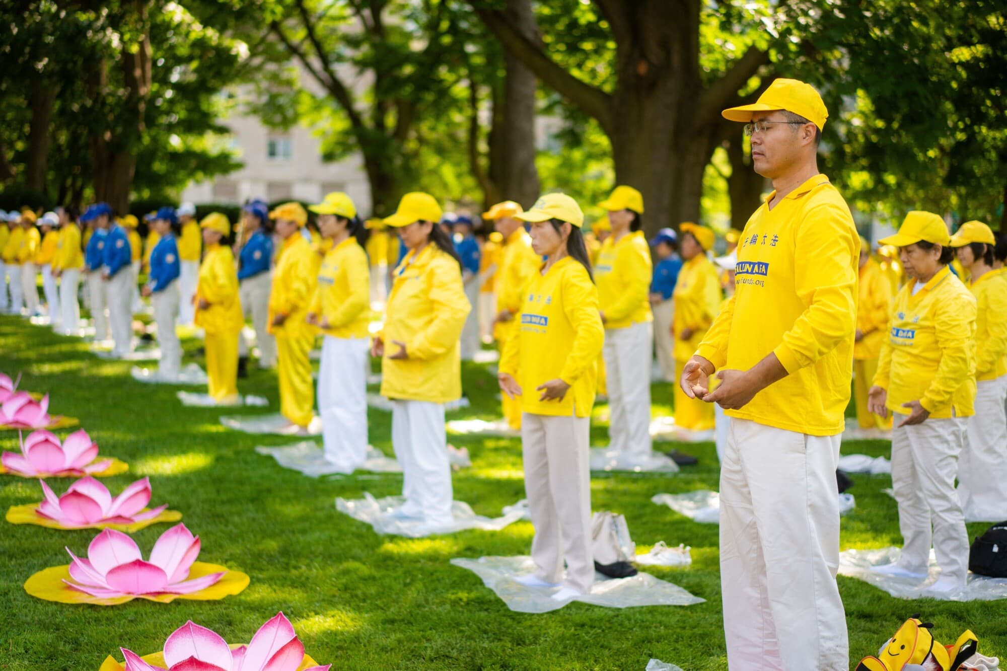 Los practicantes de Falun Gong realizan los ejercicios en una manifestación para conmemorar el 25.º aniversario de la persecución a Falun Gong en China, en el centro de Toronto, Canadá, el 20 de julio de 2024. (Evan Ning/The Epoch Times).