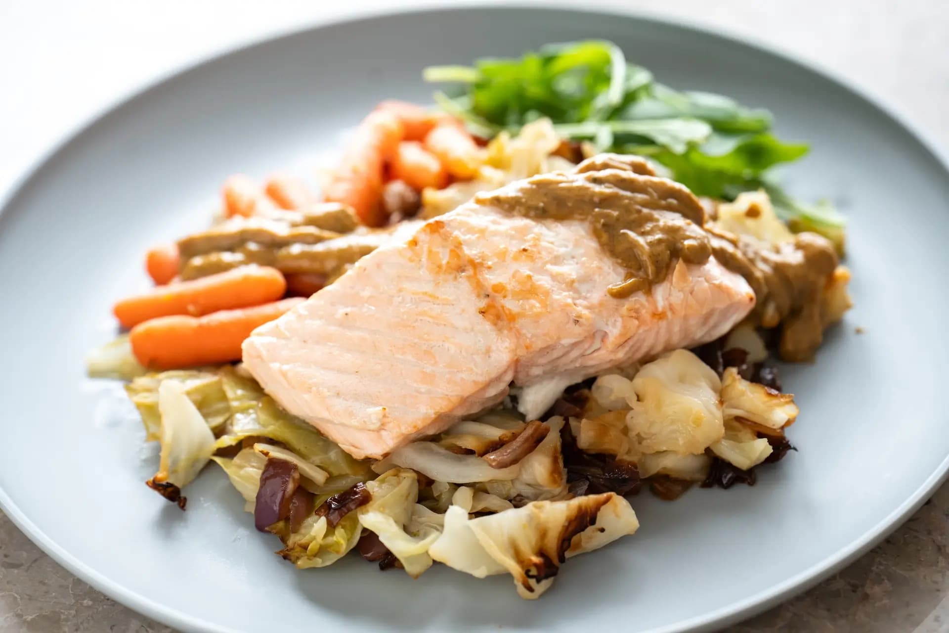 <em>Salmón al horno con verduras asadas y un toque de pesto de almendras. (Samira Bouaou/The Epoch Times)</em>