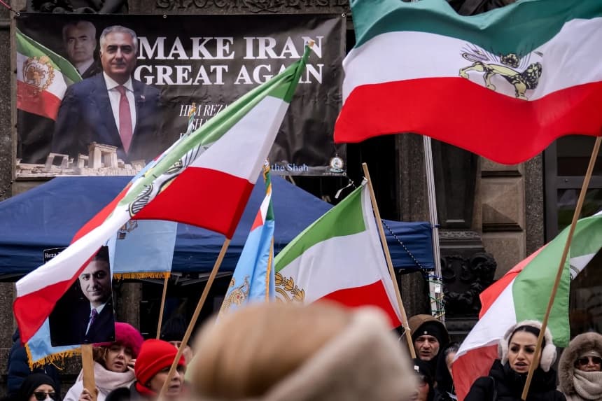 Los manifestantes sostienen pancartas con la imagen de Reza Pahlavi, un disidente iraní exiliado en Estados Unidos e hijo del último sha de Irán, y ondean banderas de la era Pahlavi durante una manifestación contra el régimen iraní en Stephansplatz, en Viena, Austria, el 11 de enero de 2026. (Joe Klamar/AFP a través de Getty Images)