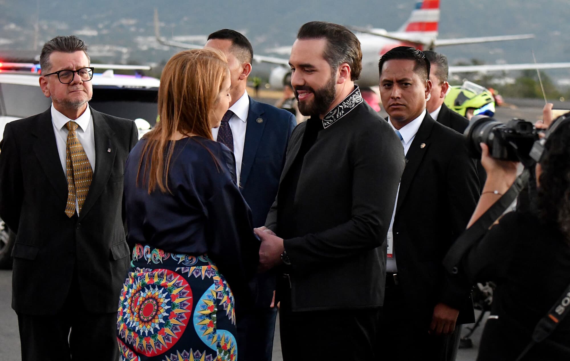 La vicepresidente de Costa Rica, Mary Munive (Izq.), saluda al presidente de El Salvador, Nayib Bukele, a su llegada al Aeropuerto Internacional Juan Santa María, en Alajuela, Costa Rica, el 13 de enero de 2026. (EZEQUIEL BECERRA/AFP vía Getty Images)