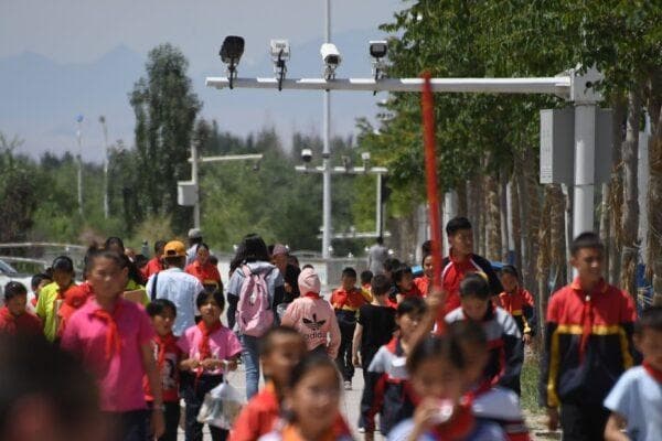 Estudiantes caminando bajo las cámaras de vigilancia en Akto, al sur de Kashgar, en la región occidental china de Xinjiang, el 4 de junio de 2019. (Greg Baker/AFP vía Getty Images)