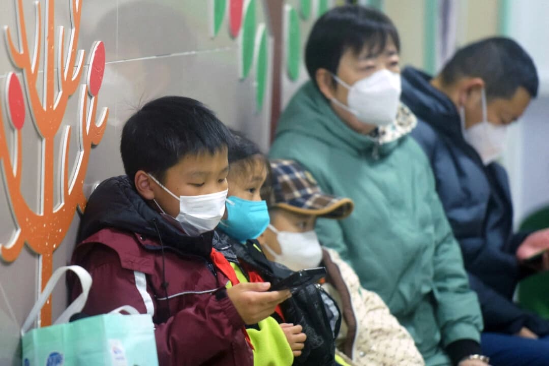 <em>Niños y adultos usando mascarillas esperan ser atendidos en el departamento de pediatría de un hospital en Hangzhou, China, el 6 de enero de 2025. (AFP vía Getty Images)</em>