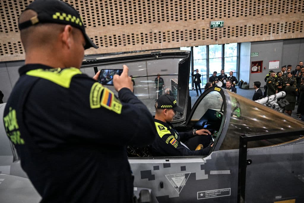 <em>Un miembro de la Policía Nacional toma una fotografía con un colega dentro de un prototipo de avión de combate Gripen durante la Expodefensa en Bogotá, el 5 de diciembre de 2023. (Foto de JUAN BARRETO/AFP vía Getty Images)</em>