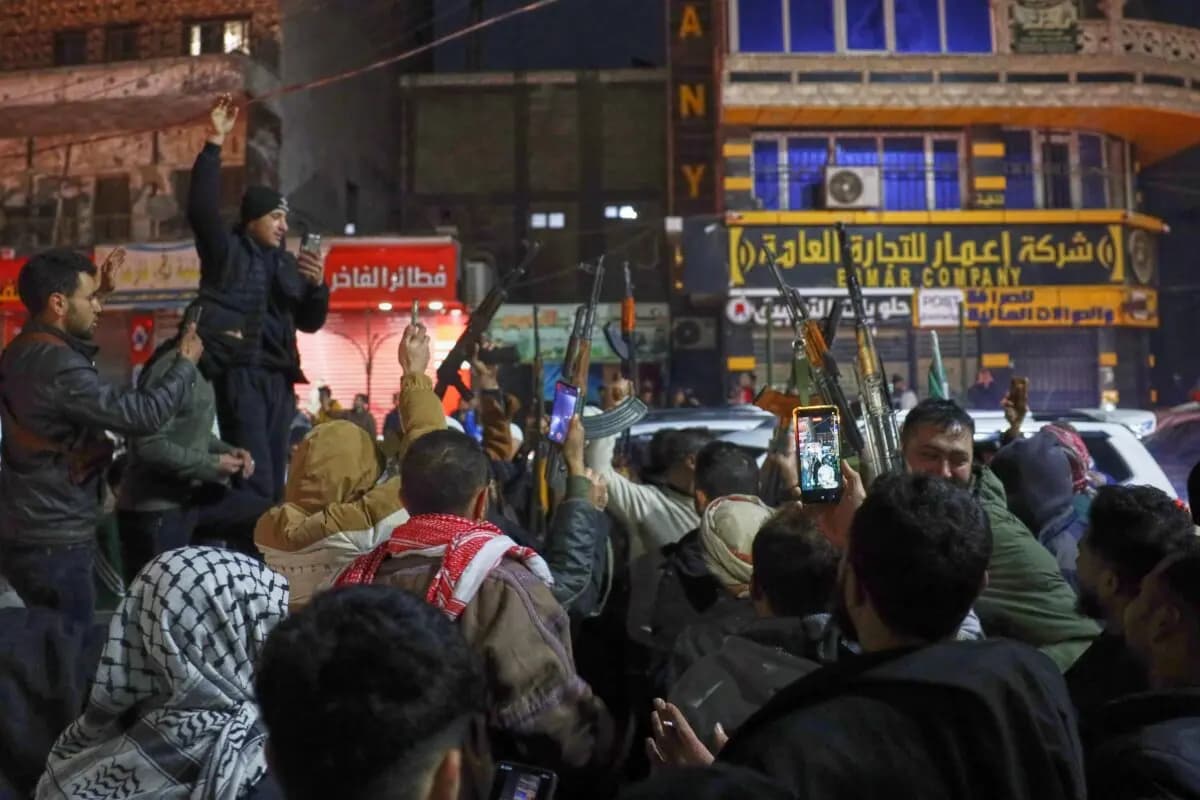 Las tropas del gobierno sirio y sus partidarios locales celebran tras tomar el control de la ciudad a las Fuerzas Democráticas Sirias (SDF), en la rotonda de Al-Naeem, en el centro de Raqqa, al noreste de Siria, el 18 de enero de 2026. (Omar Albam/AP Photo).