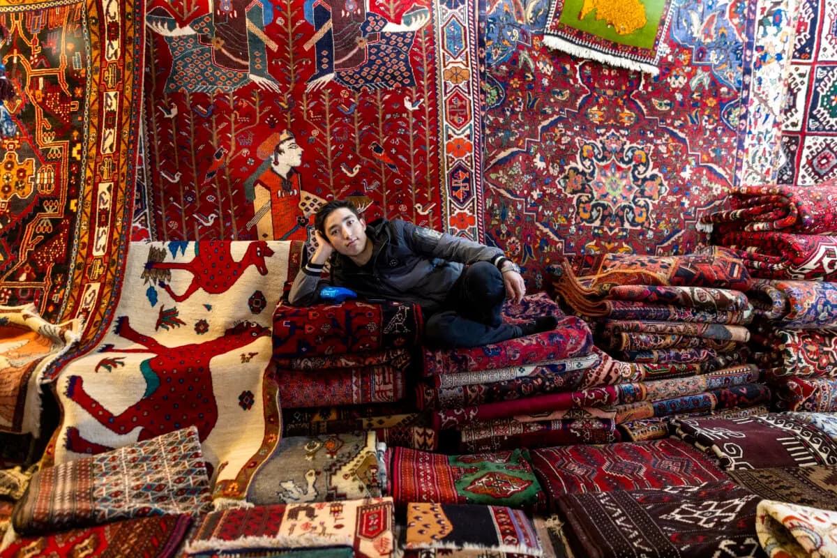 <em>Un vendedor de alfombras posa para un retrato en un mercado semanal de los viernes en Teherán, Irán, el 16 de enero de 2026. (Stringer/Getty Images)</em>