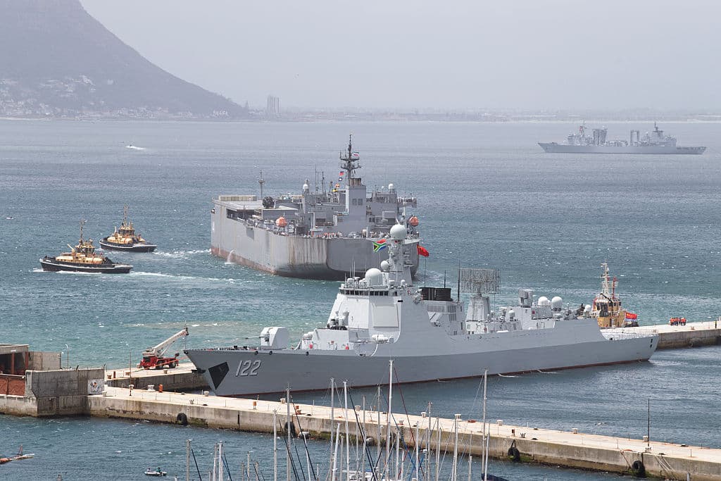 <em>Vista general (de izq. a der.) del destructor chino de misiles guiados Tangshan (casco 122), el buque de la armada iraní IRIS Makran 441 y el buque de suministro integral chino Taihu (casco 889) en el puerto de Simon's Town, cerca de Ciudad del Cabo, el 8 de enero de 2026. El ejercicio "Voluntad por la Paz 2026", liderado por China, reúne a las armadas de los países BRICS+ en operaciones conjuntas de seguridad marítima. (Foto de RODGER BOSCH / AFP vía Getty Images)</em>
