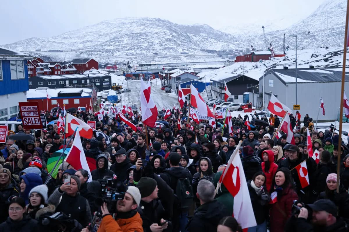 <em>La gente lleva banderas groenlandesas mientras marcha para protestar contra el presidente estadounidense Donald Trump y su intención anunciada de adquirir Groenlandia, en Nuuk, Groenlandia, el 17 de enero de 2026. Sean Gallup/Getty Images</em>