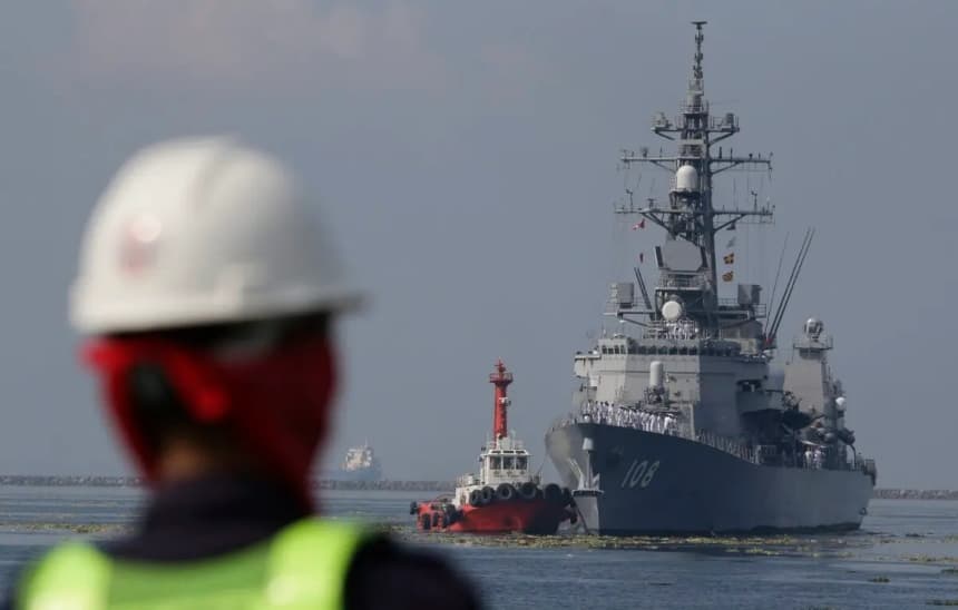 Un trabajador portuario filipino observa cómo el buque japonés Akebono (DD-108), un destructor de la clase Murasame de la Fuerza Marítima de Autodefensa de Japón, se prepara para atracar en el puerto sur de Manila, en Filipinas, el 27 de septiembre de 2018, en una visita de buena voluntad. (Aaron Favila/AP Photo)