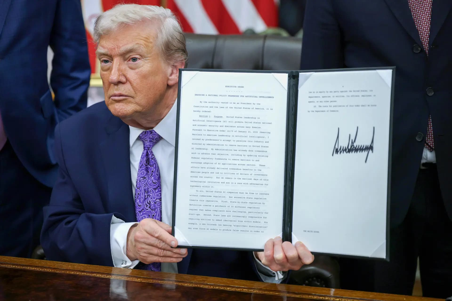 El presidente Donald Trump muestra una orden ejecutiva firmada en el Despacho Oval el 11 de diciembre de 2025. La orden ejecutiva limita la capacidad de los estados para regular la inteligencia artificial, algo por lo que la industria tecnológica ha estado presionando. (Alex Wong/Getty Images)