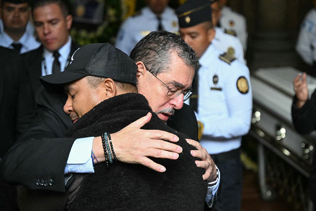 <em>El presidente de Guatemala, Bernardo Arévalo, abraza al familiar de un oficial asesinado durante un funeral en la sede del Ministerio de Gobernación en la Ciudad de Guatemala el 19 de enero de 2026. (Foto de JOHAN ORDONEZ / AFP vía Getty Images)</em>