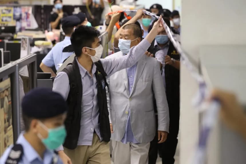 Foto de Apple Daily en la que se ve al magnate empresarial de Hong Kong Jimmy Lai escoltado por agentes de policía durante un registro en la sede de Apple Daily tras su detención en su domicilio de Hong Kong, el 10 de agosto de 2020. (Handout/Getty Images)