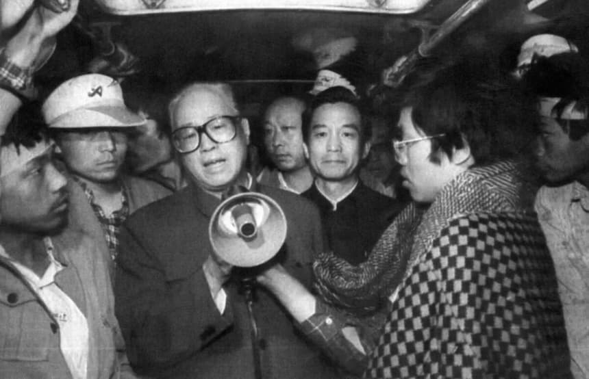 El secretario general del Partido Comunista Chino (PCCh), Zhao Ziyang (centro), se dirige a los estudiantes en huelga de hambre a través de un megáfono en la madrugada del 19 de mayo de 1989, en uno de los autobuses de la plaza de Tiananmen en Beijing, donde se había dado refugio a los huelguistas prodemocráticos. (Xinhua/AFP a través de Getty Images)