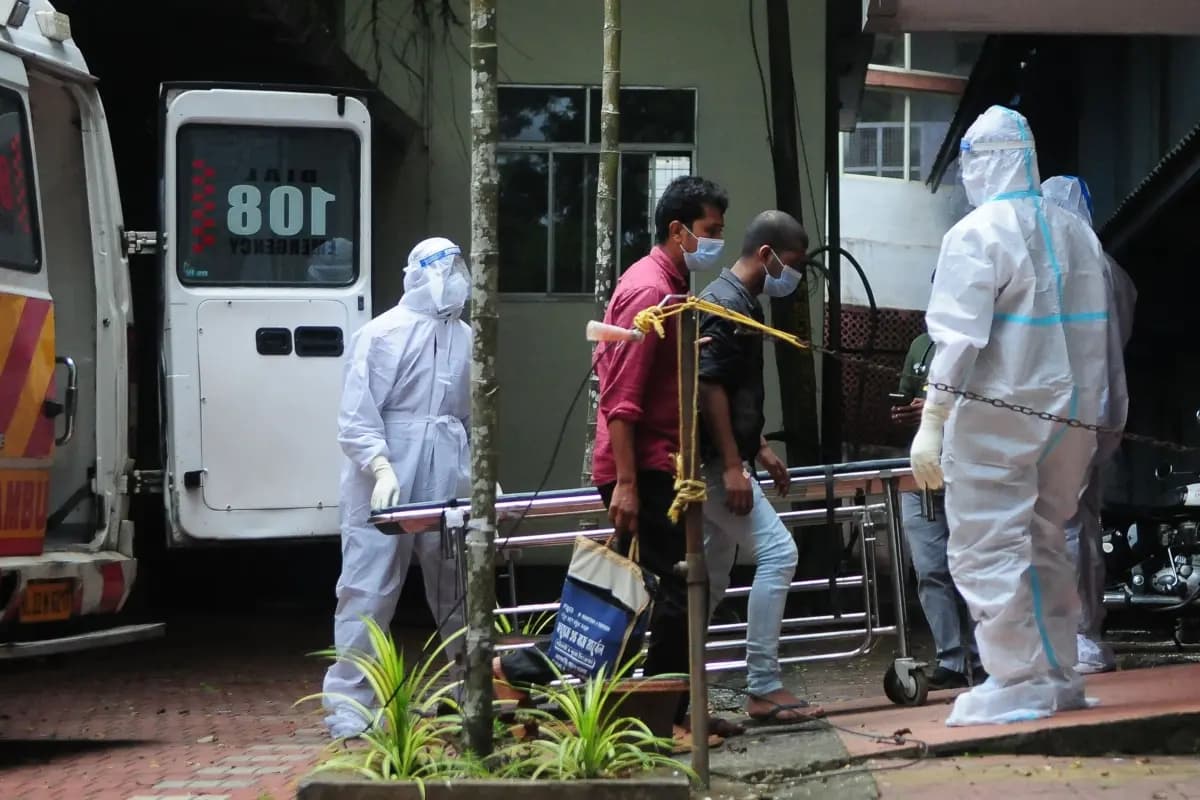 <em>Trabajadores sanitarios con equipo de protección trasladan a personas que estuvieron en contacto con una persona infectada con el virus Nipah a un centro de aislamiento en Kerala, India, el 14 de septiembre de 2023. (AFP vía Getty Images)</em>