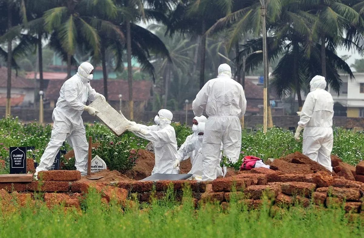 <em>Médicos y familiares con equipo de protección cavan una tumba para enterrar el cuerpo de una víctima del virus Nipah el 24 de mayo de 2018. (Stringer/Reuters)</em>