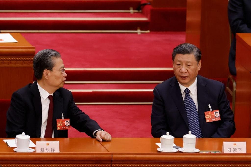 El líder chino Xi Jinping habla con el presidente de la Asamblea Popular Nacional, Zhao Leji, durante la quinta sesión plenaria de la Asamblea Popular Nacional, el órgano legislativo chino, en Beijing, el 12 de marzo de 2023. (Lintao Zhang/Getty Images)