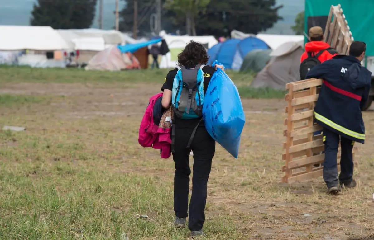 Personas transportan objetos en un campamento improvisado para migrantes en la frontera entre Grecia y Macedonia, cerca de la aldea de Idomeni, el 3 de mayo de 2016. (Tobia Schwarz/AFP/Getty Images).
