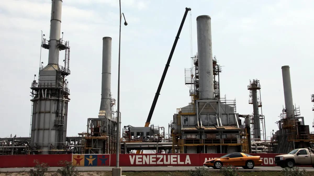 <em>Autos pasan frente a la refinería de petróleo en la ciudad venezolana de Morón el 30 de abril de 2009. El sector petrolero domina la economía mixta venezolana, representando alrededor del 80 % de las exportaciones. (Thomas Coex/AFP vía Getty Images)</em>