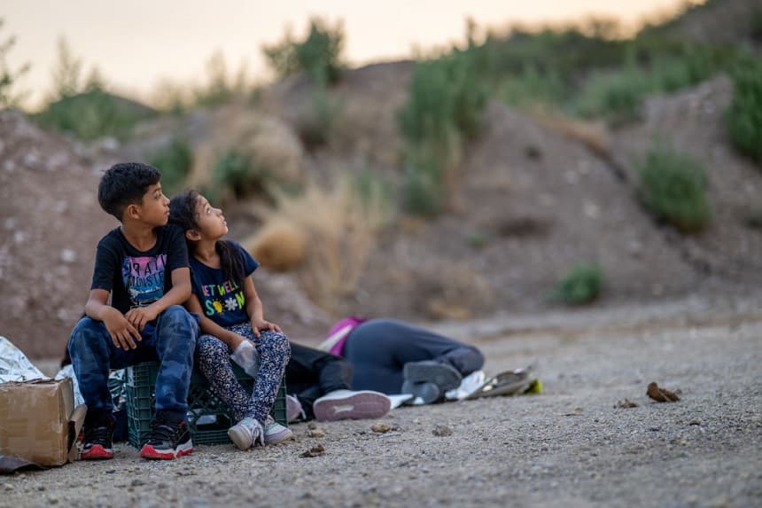 Los hijos de la familia Rivera miran hacia el cielo mientras esperan a ser detenidos por los agentes de Aduanas y Protección Fronteriza de Estados Unidos tras cruzar la frontera hacia Estados Unidos el 26 de junio de 2024 en Ruby, Arizona. (Brandon Bell/Getty Images)