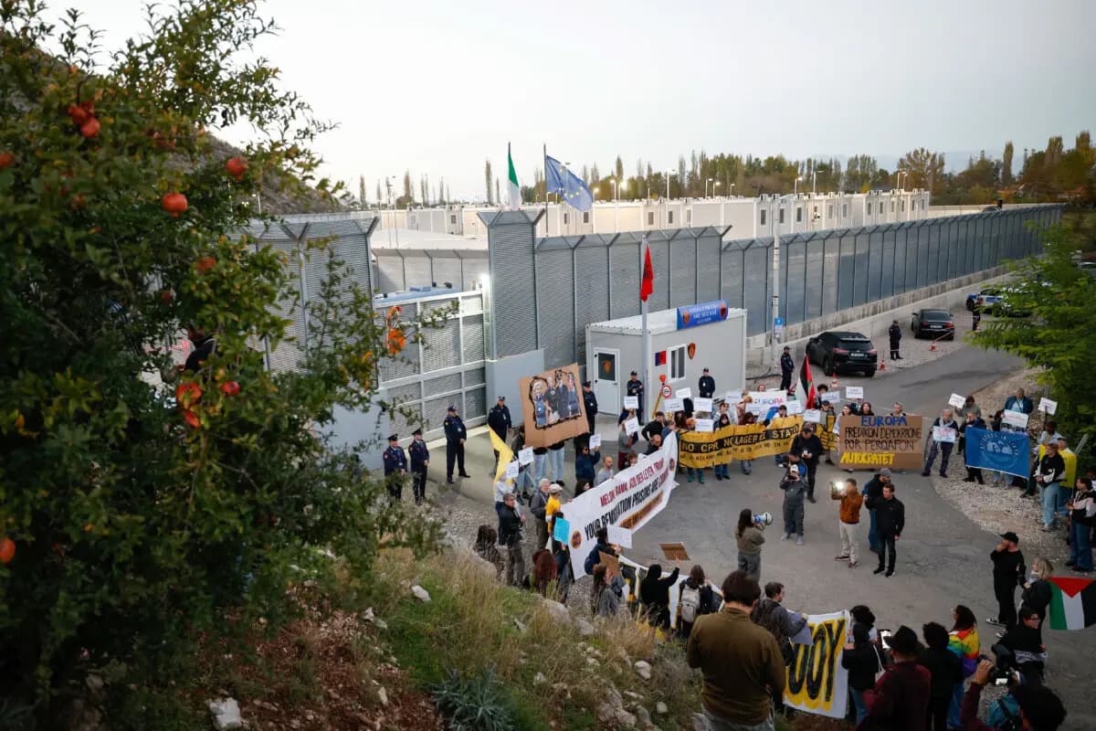 Activistas de Italia, Albania y otros países europeos se reúnen para protestar contra los campos de migrantes construidos en virtud de un acuerdo entre Roma y Tirana, frente al centro de detención gestionado por Italia en Gjader, Albania, el 1 de noviembre de 2025. (Adnan Beci/AFP a través de Getty Images)