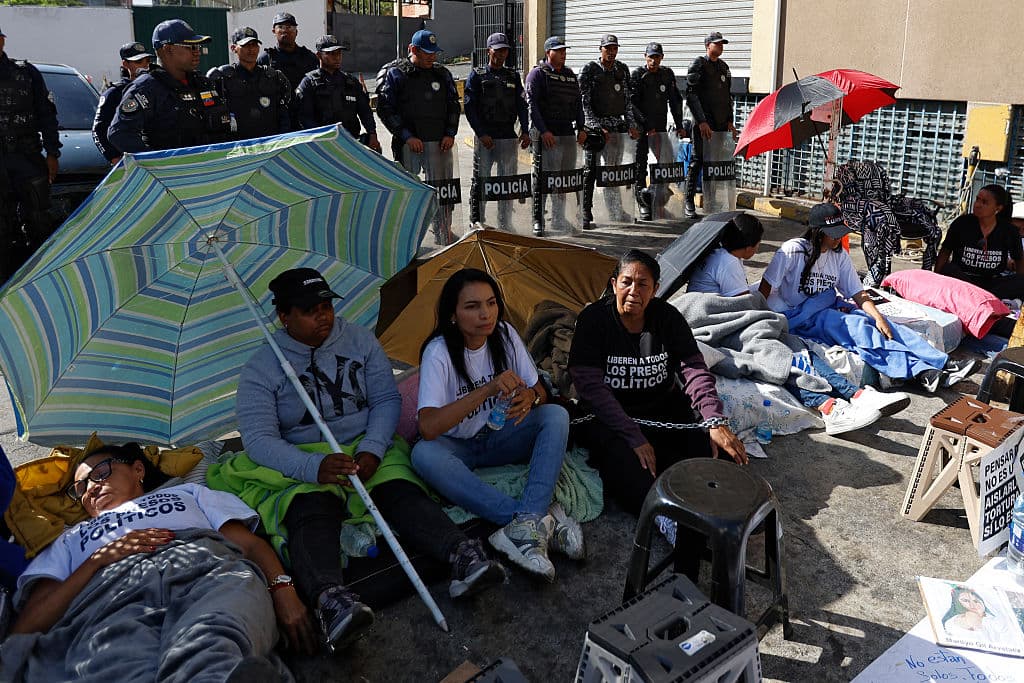 <em>Familiares de presos políticos protestan frente a una hilera de policías frente a la cárcel Zona 7 de la Policía Nacional Bolivariana (PNB) en Caracas, el 13 de febrero de 2026. El jueves, los legisladores venezolanos pospusieron la aprobación de un proyecto de ley de amnistía histórica, diseñado para poner fin al uso de los tribunales para reprimir la disidencia, tras no llegar a un acuerdo sobre su aplicación. (Foto de Pedro MATTEY / AFP vía Getty Images)</em>