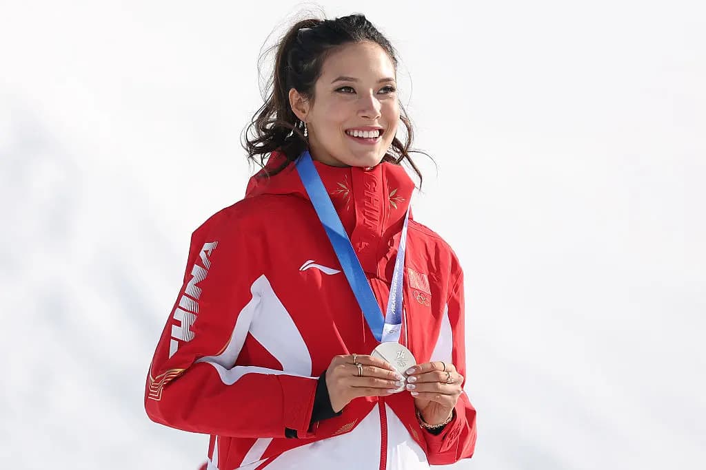 <em>La medallista de plata Ailing Eileen Gu, del equipo de la República Popular China, celebra en el podio después de la final de slopestyle femenino en el tercer día de los Juegos Olímpicos de Invierno Milano Cortina 2026 en el Livigno Snow Park en Livigno, Italia, el 9 de febrero de 2026. (Michael Reaves/Getty Images)</em>