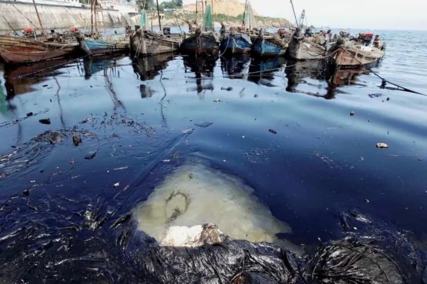 Un barco y restos flotando en una mancha de petróleo en el mar Amarillo, tras un enorme derrame provocado por el incendio de un oleoducto en el puerto de Dalian, provincia de Liaoning, China. (AFP/Getty Images)