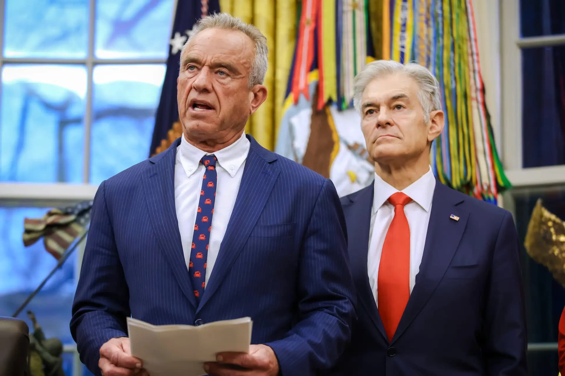 El Secretario de Salud Robert F. Kennedy Jr. (L) habla en el Despacho Oval el 29 de enero de 2026. Una nueva coalición compuesta por 15 grupos, incluida una organización fundada por Kennedy, está atacando los mandatos de vacunación y mascarilla en todo Estados Unidos. (Samuel Corum/Getty Images)