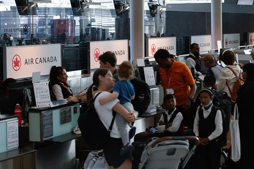 Los pasajeros esperan en el mostrador de facturación de Air Canada en el Aeropuerto Internacional Pearson el 14 de agosto de 2025 en Toronto, Canadá. (Cole Burston/Getty Images)