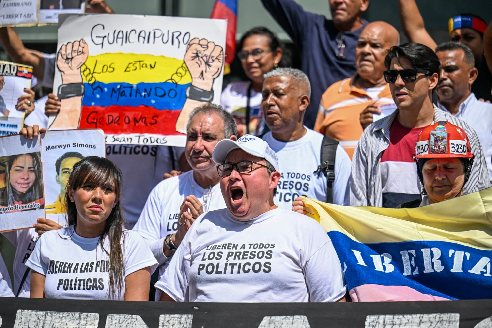 <em>Familiares de presos políticos sostienen carteles alusivos y retratos de sus seres queridos mientras protestan frente a la sede de las Naciones Unidas en Caracas, el 18 de febrero de 2026. (Juan BARRETO / AFP a través de Getty Images).</em>