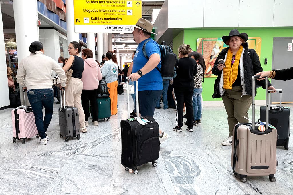 <em>Pasajeros permanecen varados en el Aeropuerto Internacional de Guadalajara tras la suspensión de vuelos y la falta de transporte en Tlajomulco, Jalisco, México, el 22 de febrero de 2026. México confirmó el 22 de febrero que soldados abatieron a un poderoso líder del narcotráfico, uno de los hombres más buscados tanto en México como en Estados Unidos. (Foto de Ulises Ruiz / AFP vía Getty Images)</em>