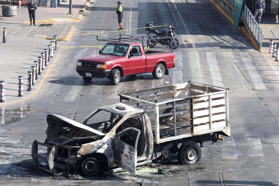 <em>Los restos quemados de un camión, utilizado como barricada por miembros del cártel en represalia por el asesinato del notorio líder del cártel "El Mencho" a manos de las fuerzas mexicanas, yacen en Guadalajara, México, el 22 de febrero de 2026. (Michelle Freyria/Reuters)</em>