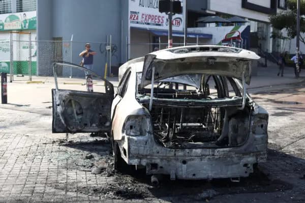 Un vehículo quemado utilizado como barricada por miembros del crimen organizado, tras una serie de detenciones por parte de las fuerzas federales, en Guadalajara, México, el 22 de febrero de 2026. (Michelle Freyria/Reuters).