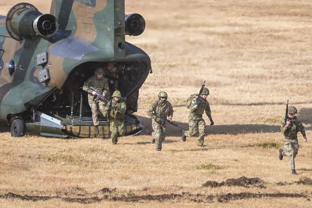Soldados de varios países salen de un helicóptero durante un ejercicio militar conjunto llevado a cabo por la 1.ª Brigada Aerotransportada de la Fuerza Terrestre de Autodefensa de Japón con participantes de Gran Bretaña, Canadá, Alemania, Estados Unidos y otros países en el campamento Narashino en Funabashi, Japón, el 7 de enero de 2024. (Richard A. Brooks/AFP a través de Getty Images)
