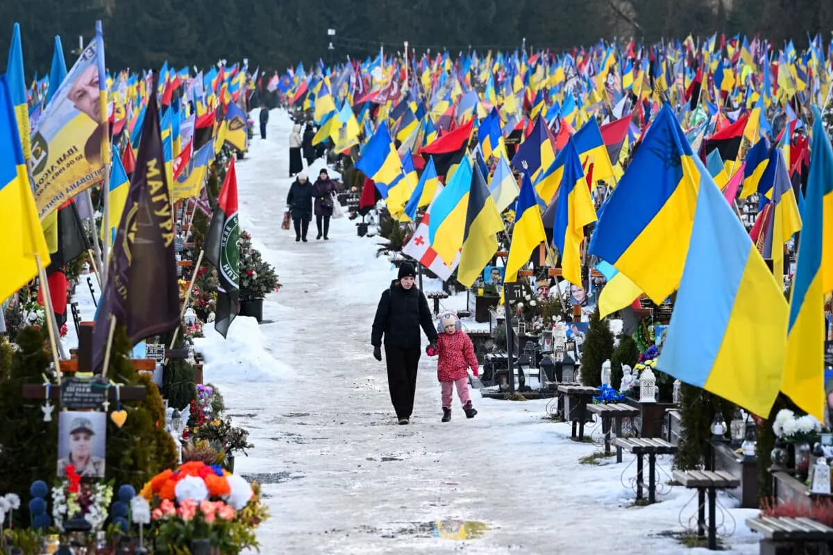 Los dolientes caminan el día de San Valentín por el cementerio militar de Lychakiv, en Lviv (Ucrania), el 14 de febrero de 2026. (Yuriy Dyachyshyn/ AFP a través de Getty Images).