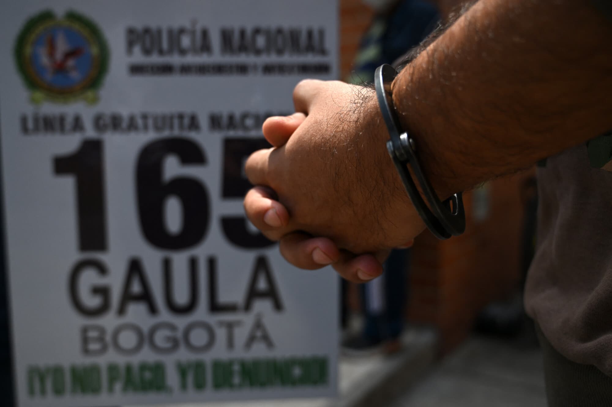 <em>Una foto de archivo de un presunto extorsionador en la comisaría de Gaula (Grupos de Acción Unificada para la Libertad Personal), tras ser detenido en Bogotá el 20 de febrero de 2024. (RAÚL ARBOLEDA/AFP vía Getty Images)</em>