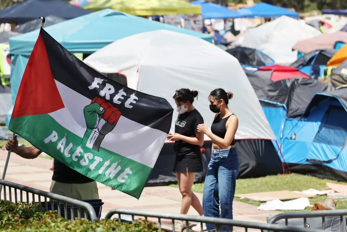 <em>Un manifestante lleva una bandera palestina en un campamento pro palestino en el campus de la Universidad de California en Los Ángeles (UCLA) en Los Ángeles el 30 de abril de 2024. (Mario Tama/Getty Images)</em>