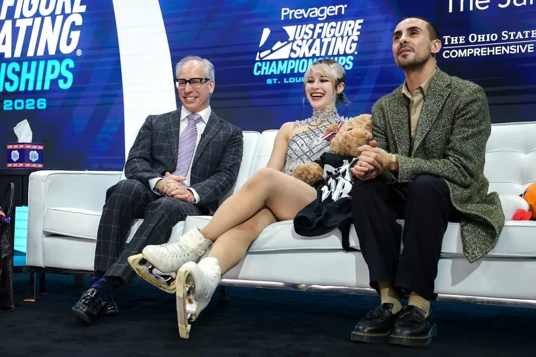 Alysa Liu celebra en la zona Kiss and Cry con sus entrenadores Phillip DiGuglielmo y Massimo Scali después del programa libre femenino durante el Campeonato de Patinaje Artístico de Estados Unidos de 2026 en St. Louis, el 9 de enero de 2026. (Matthew Stockman/Getty Images)