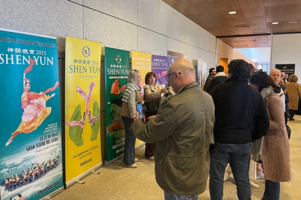La noche del 25 de febrero de 2026, el vestíbulo del teatro exhibía carteles de los espectáculos de Shen Yun de años anteriores, y los espectadores tomaban fotografías como recuerdo. (Jun Zhuo / The Epoch Times)