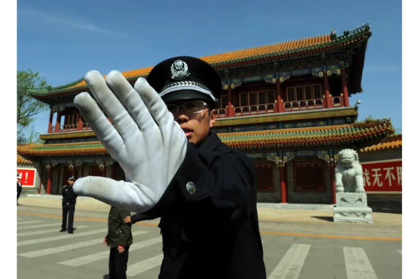 Un policía chino bloquea a un fotógrafo en las afueras de Zhongnanhai, que sirve como sede central del PCC, tras el despido de Bo Xilai, en Beijing el 11 de abril de 2012. (Mark Ralston/AFP/Getty Images)