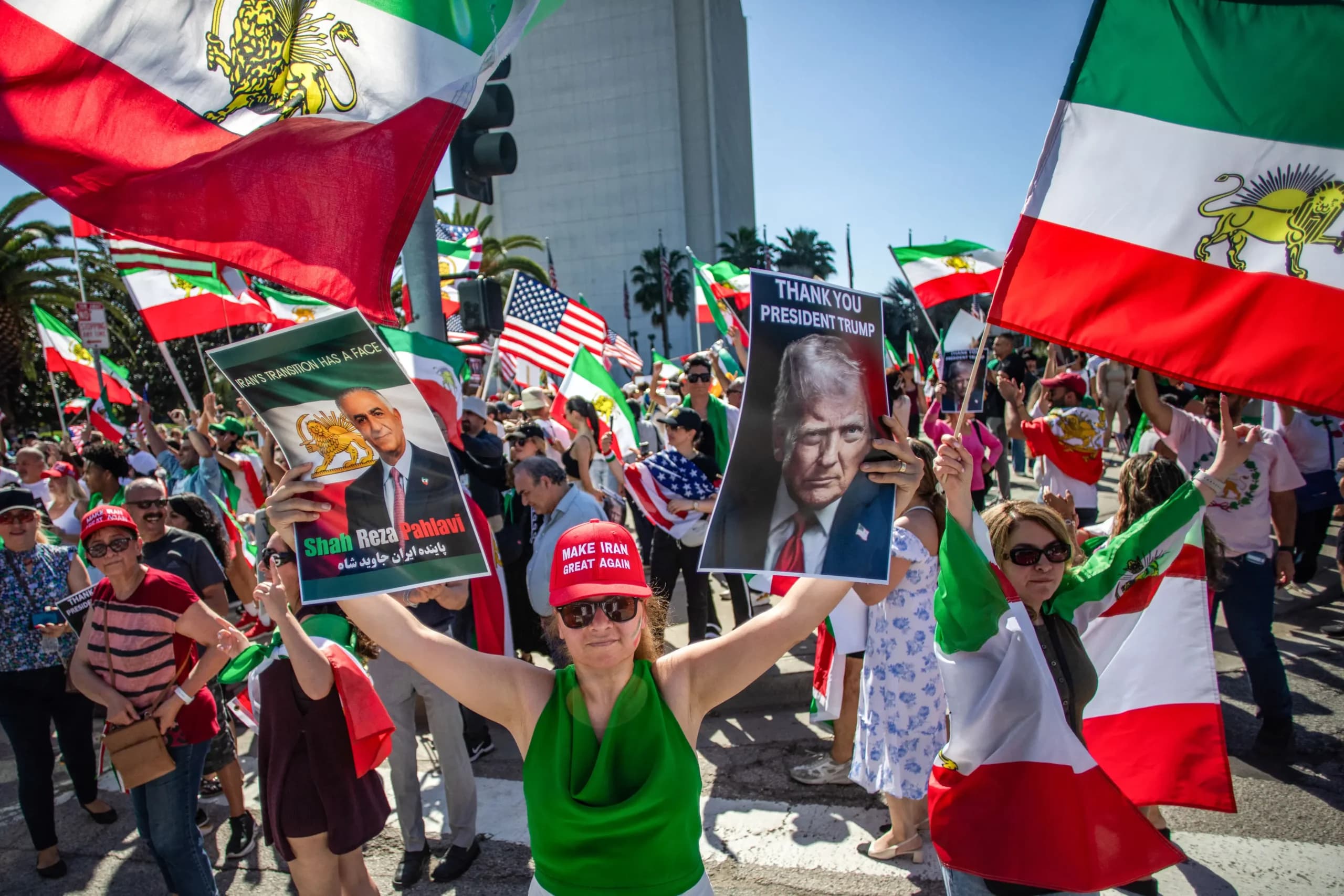 <em>Una mujer sostiene fotografías de Reza Pahlavi y del presidente estadounidense Donald Trump mientras miembros de la comunidad iraní celebran frente al Edificio Federal en Los Ángeles el 28 de febrero de 2026. (Apu GOMES / AFP vía Getty Images)</em>