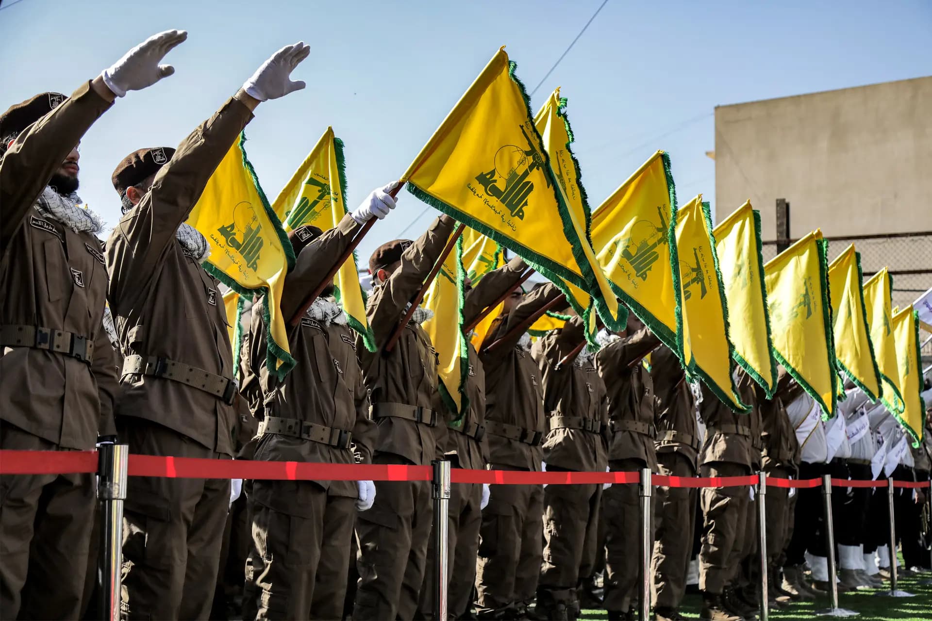 Miembros de Hezbolá saludan y enarbolan las banderas amarillas del grupo durante el funeral de sus compañeros caídos Ismail Baz y Mohamad Hussein Shohury, que murieron en un ataque israelí contra sus vehículos, en Shehabiya, Líbano, el 17 de abril de 2024. (-/AFP vía Getty Images)