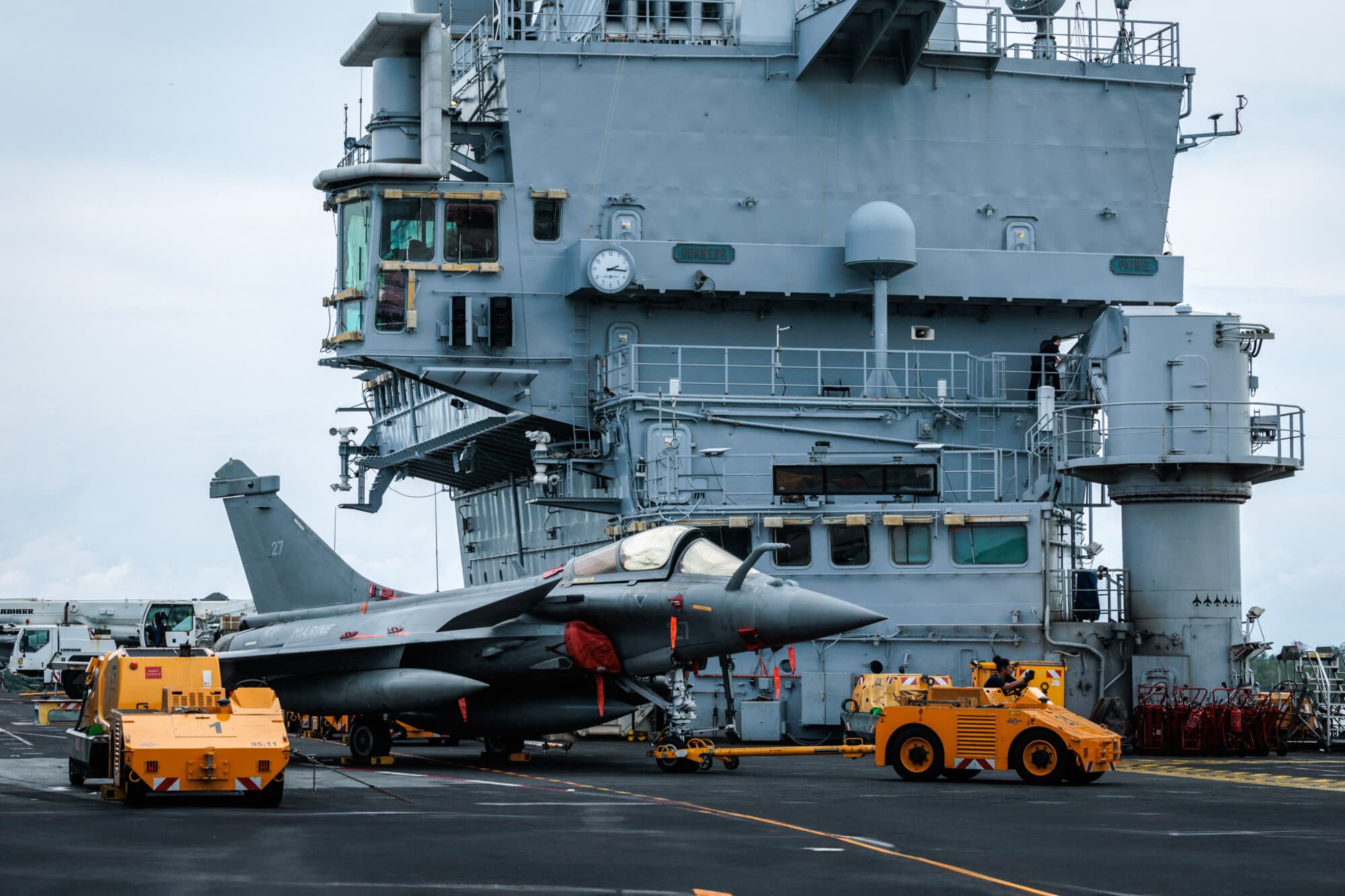 <em>Un avión de combate Rafale es remolcado en la cubierta de vuelo del portaaviones nuclear Charles de Gaulle de la Armada francesa durante su primera escala en Indonesia como parte de la misión Clemenceau 25, un despliegue de cuatro meses que cubre las regiones del Mediterráneo y el Indopacífico para mejorar la cooperación con las armadas aliadas, en la isla de Lombok, al este de Bali, el 28 de enero de 2025. (Yasuyoshi Chiba/AFP vía Getty Images)</em>