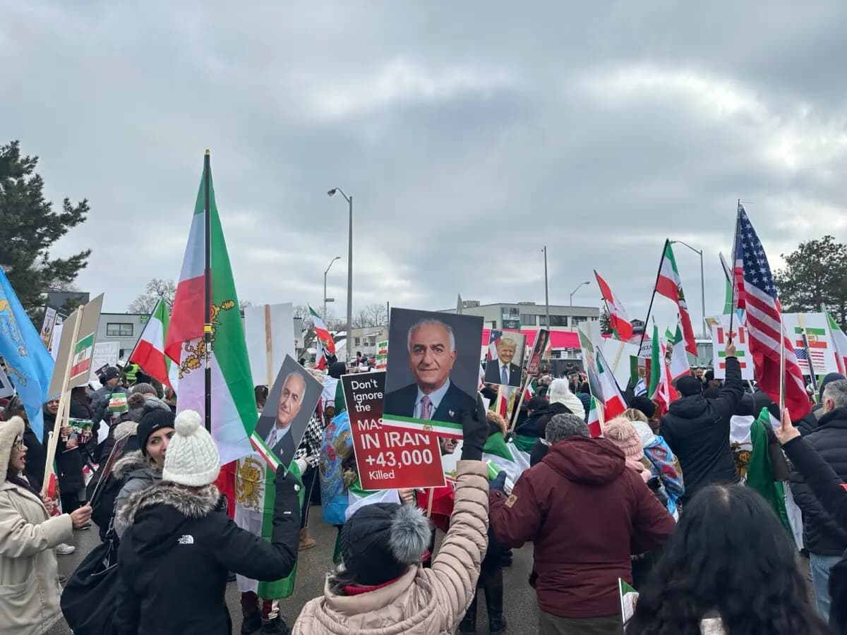 Manifestantes que exigen un cambio de régimen en Irán, con banderas nacionales iraníes anteriores a la revolución de 1979 y fotografías del príncipe heredero exiliado Reza Pahlavi, protestan en Toronto el 14 de febrero de 2026. (The Epoch Times)