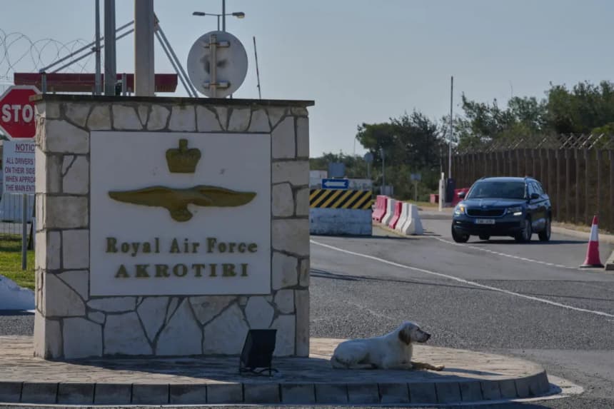 Un perro se sienta a la entrada principal de la base aérea británica RAF Akrotiri tras ser alcanzada por un ataque con drones a primera hora de la mañana cerca de Limassol, Chipre, el 2 de marzo de 2026. (Petros Karadjias/AP)
