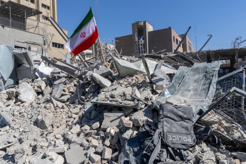 Una bandera iraní es colocada entre los escombros de una estación de policía, dañada por ataques aéreos el día de ayer, el 3 de marzo de 2026 en Teherán, Irán.(Majid Saeedi/Getty Images)